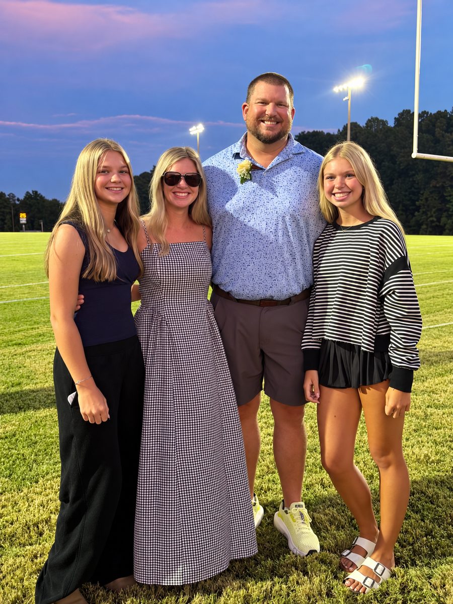 Will Hunt with his wife and two daughters on a ball field at dusk